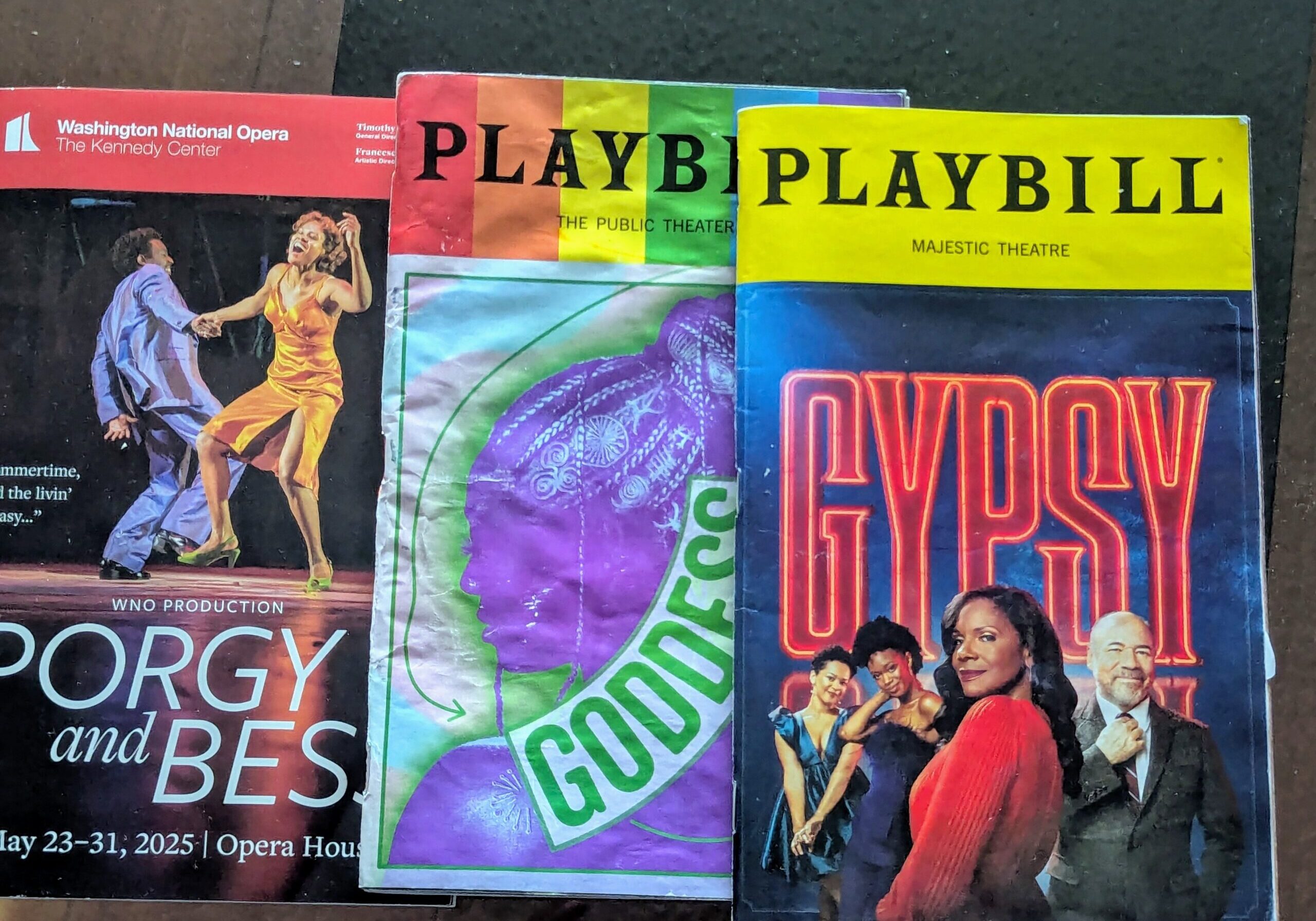 Three colorful theater playbills on display.
